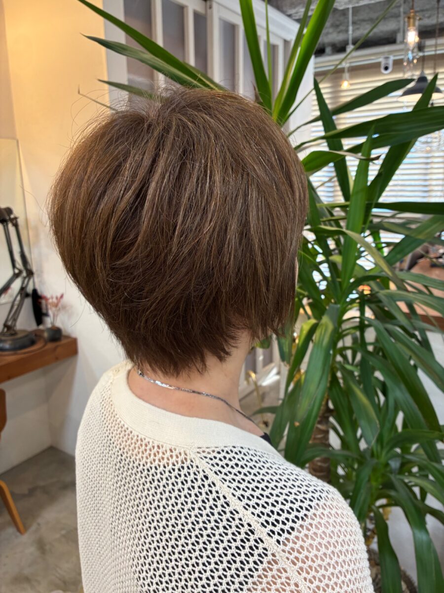 分け目を作らずふんわり立ち上げた栗色ショートの後頭部